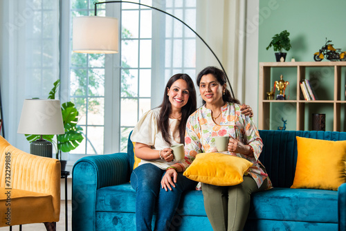 Indian Mother and daughter drink tea or coffee at home