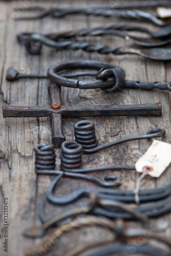 Blacksmithing tools and cross laid out on wood vertical