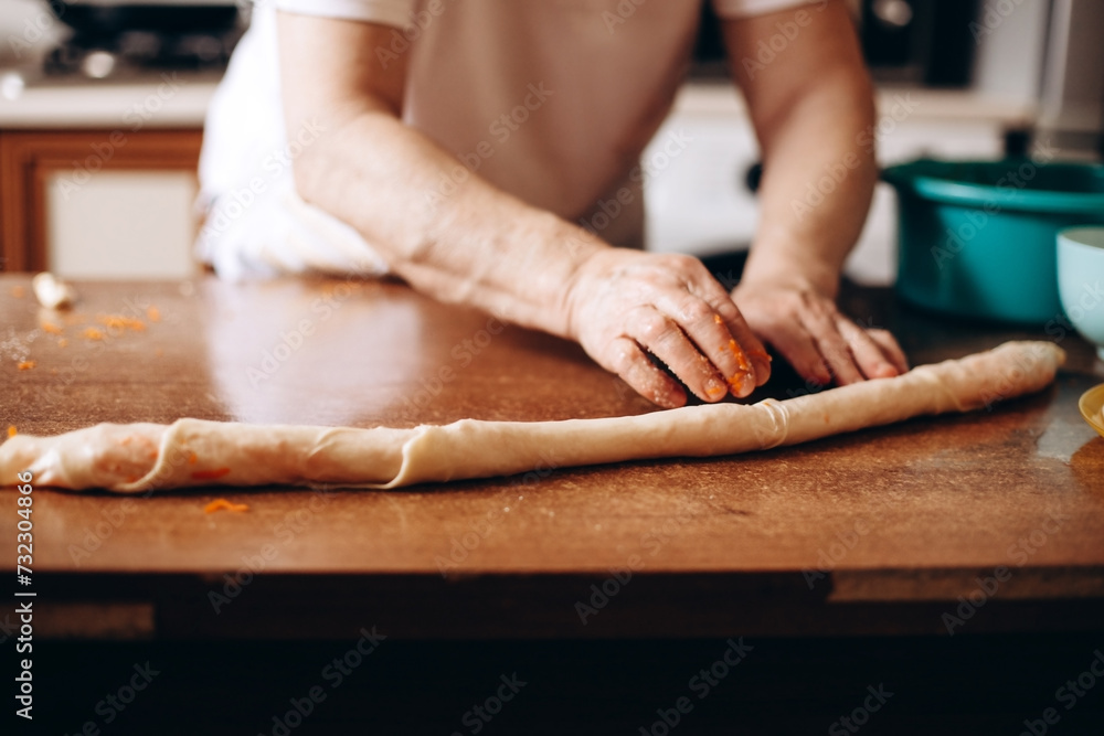 Person preparing pastries from dough with pumpkin Person preparing pastries from dough with pumpkin