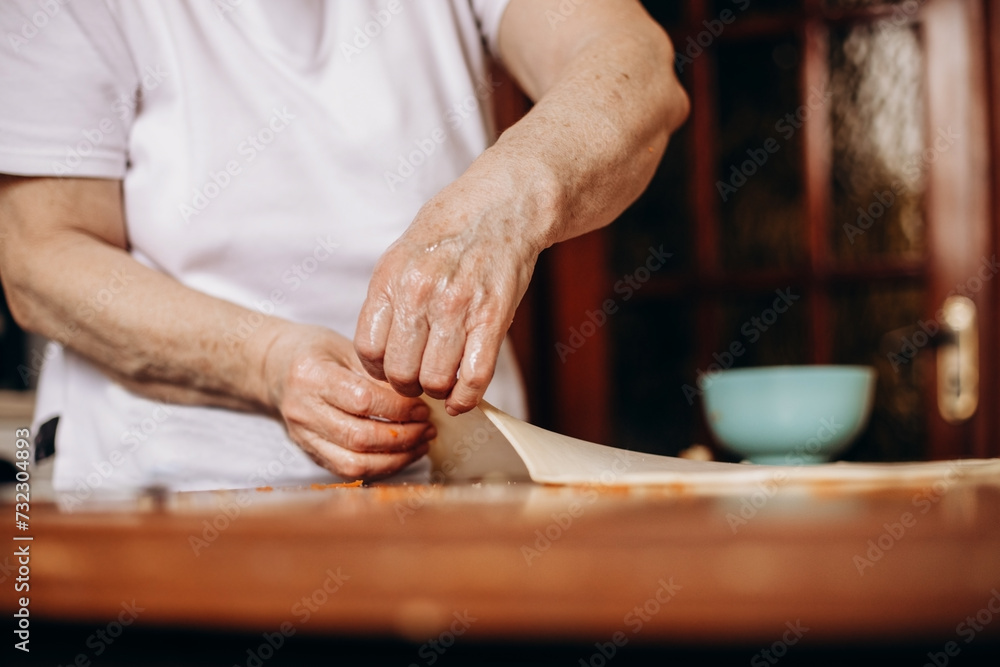 Person preparing pastries from dough with pumpkin