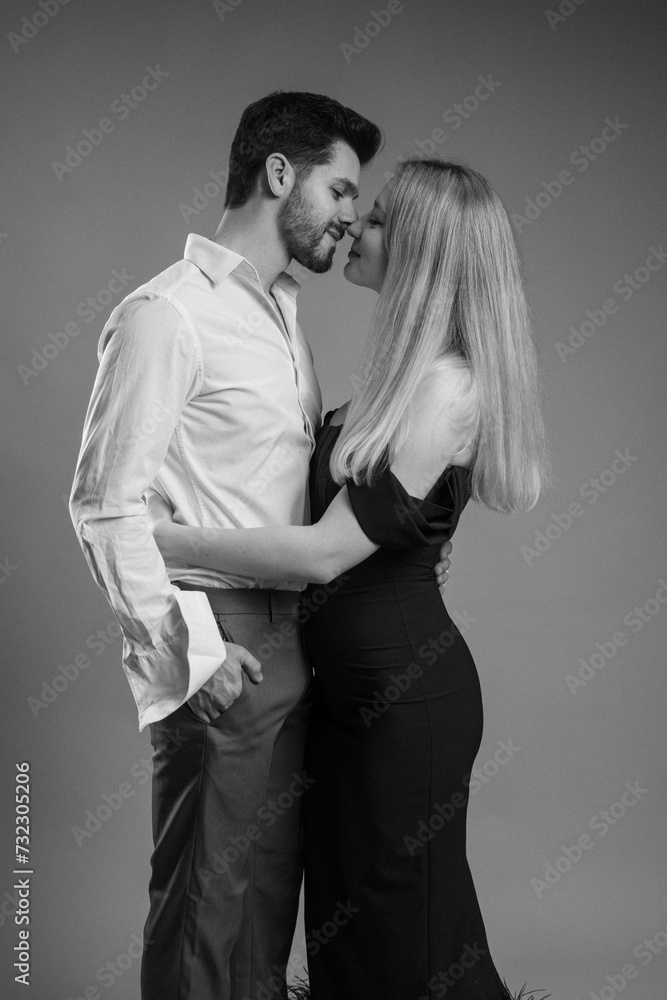 Attractive young couple posing in studio black and white photo