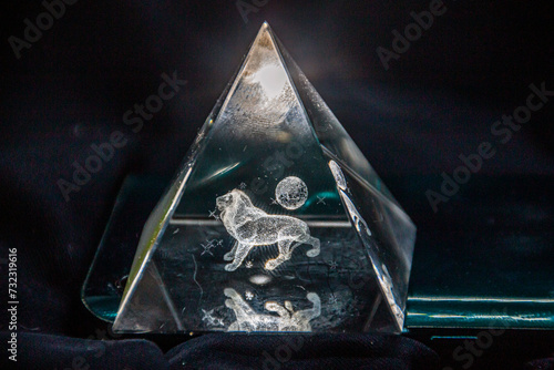 Volumetric 3D lion inside a transparent triangle on a black background photo