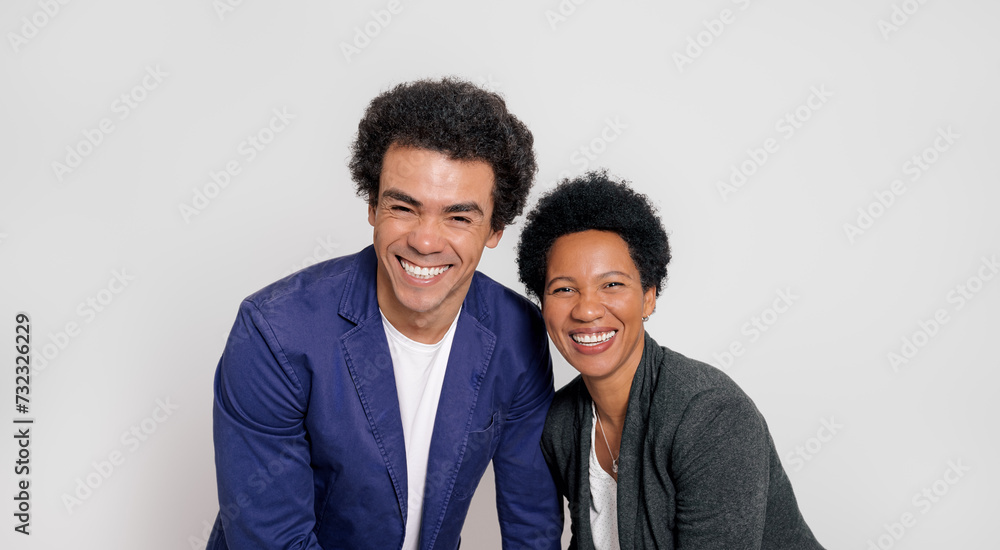 Portrait of cheerful young colleagues with afro hairstyle smiling at camera over white background Portrait of cheerful young colleagues with afro hairstyle smiling at camera over white background