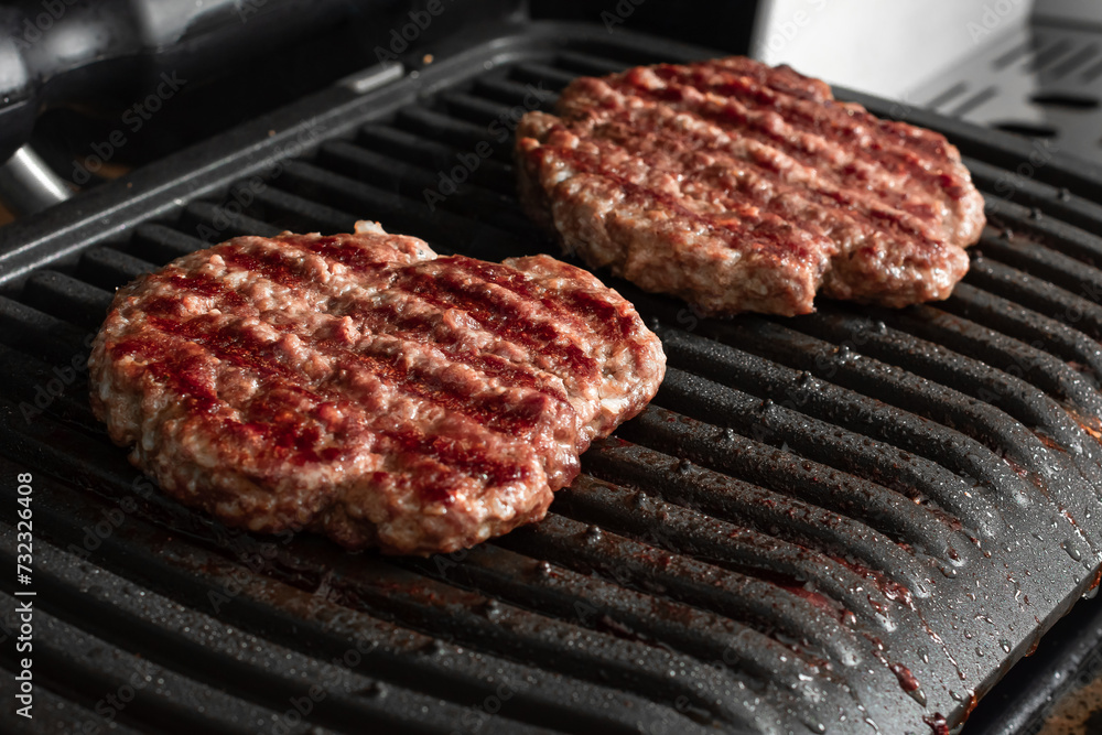 Beef cutlet for burger on grid grill Beef cutlet for burger on grid grill