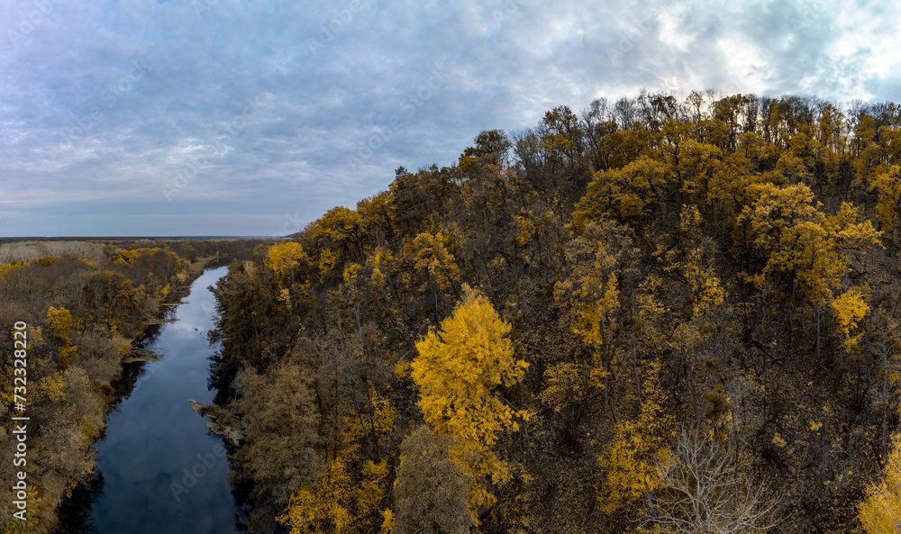 Autumn panorama, aerial river and yellow trees forest with cloudy sky. Flying above riverside in Ukraine Autumn panorama, aerial river and yellow trees forest with cloudy sky. Flying above riverside in Ukraine