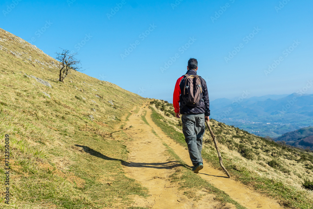 A man walking on Mount Ernio or Hernio in Gipuzkoa at sunset, Basque Country A man walking on Mount Ernio or Hernio in Gipuzkoa at sunset, Basque Country