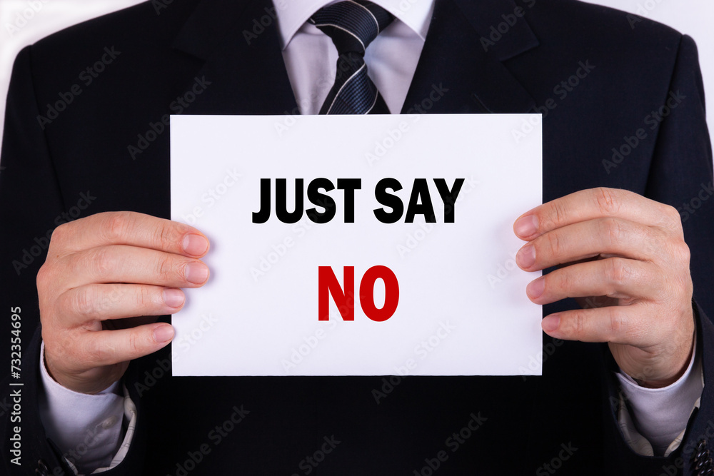 Businessman holding a card with text just say no Businessman holding a card with text just say no