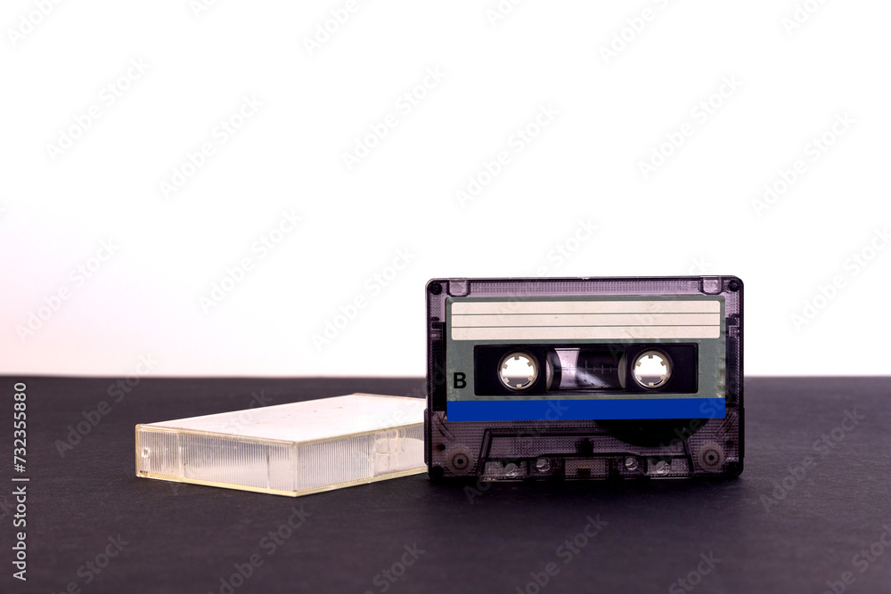 Retro audio cassette tape from the 80s on a black background.