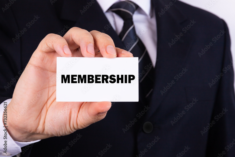 Businessman holding a card with text Membership Businessman holding a card with text Membership