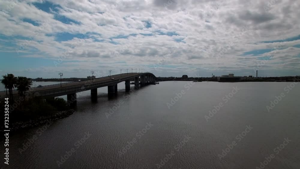 Aerial Ascending Shot Of Cars Moving On Segmental Bridge In City, Drone Flying Forward Over Halifax River On Sunny Day - Daytona Beach , Florida Aerial Ascending Shot Of Cars Moving On Segmental Bridge In City, Drone Flying Forward Over Halifax River On Sunny Day - Daytona Beach , Florida