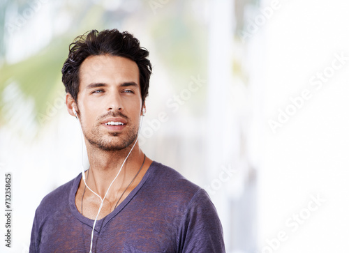 Man, thinking and smile with earphones for idea, podcast or streaming online on mockup. Male person, happy and confident with listening to music on headphones for enjoyment, fun and wellness