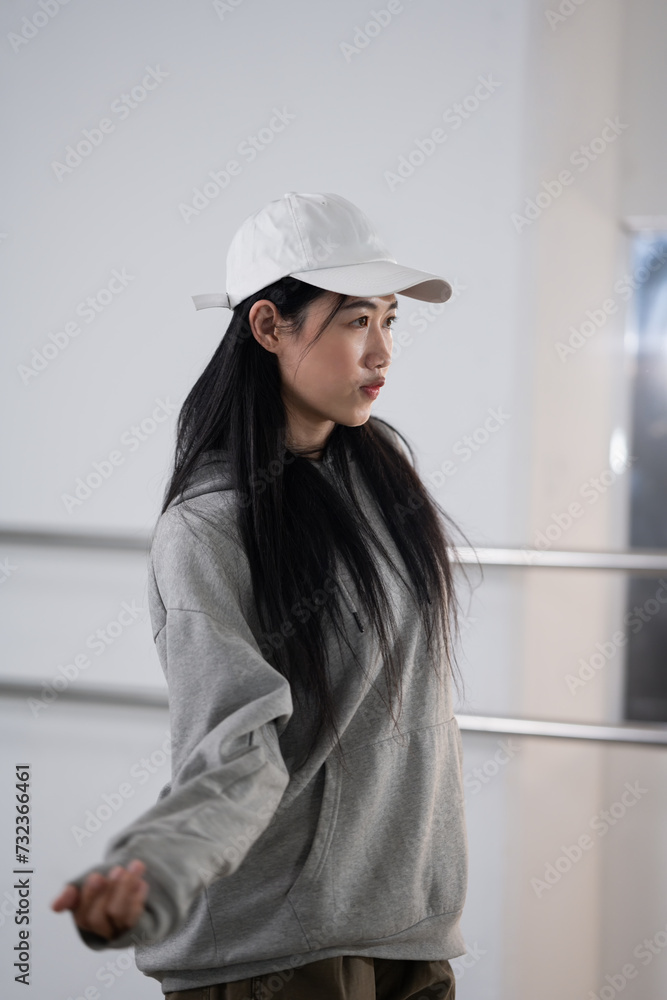 Young woman practicing modern hip hop dance in studio. Youth culture, movement and hobby concept Young woman practicing modern hip hop dance in studio. Youth culture, movement and hobby concept