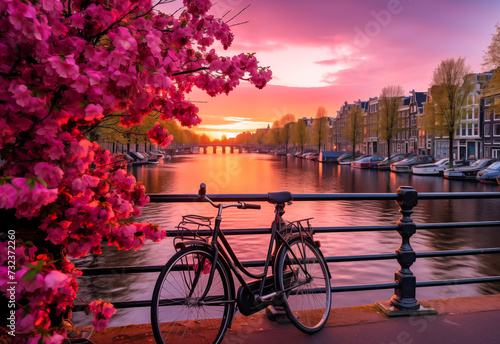 Beautiful sunrise over Amsterdam, The Netherlands, with flowers and bicycles on the bridge in the spring