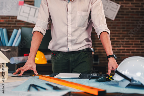 architecture, architect, construction, engineer, project, design, blueprint, house, model, plan. architect or engineer look down on blueprint with a pencil, a ruler, and engineering tools at desk.