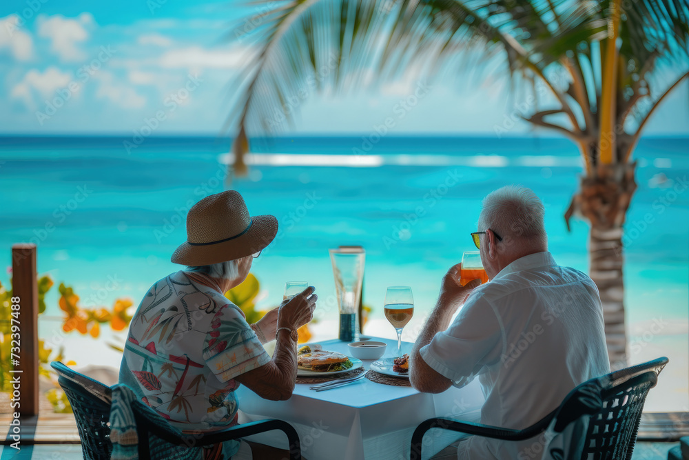 A senior couple eats food and enjoys the ocean view. Tropical vacation dining table. The concept of travel