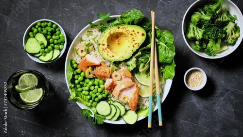 Salmon avocado bowl with broccoli, green peas, rice and fresh salad. Healthy food, poke bowl salad. Stock footage video 4k photo