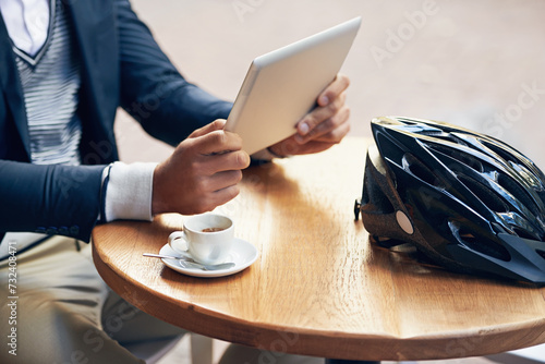 Businessman, hands and outdoor at cafe with tablet for reading news, article or travel research. Online, communication and cyclist with tech for social media, networking and scroll blog on website photo