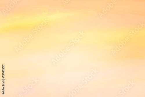 Twilight sky with effect of light in pastel yellow, orange tones. Colorful sunset of soft clouds. Background