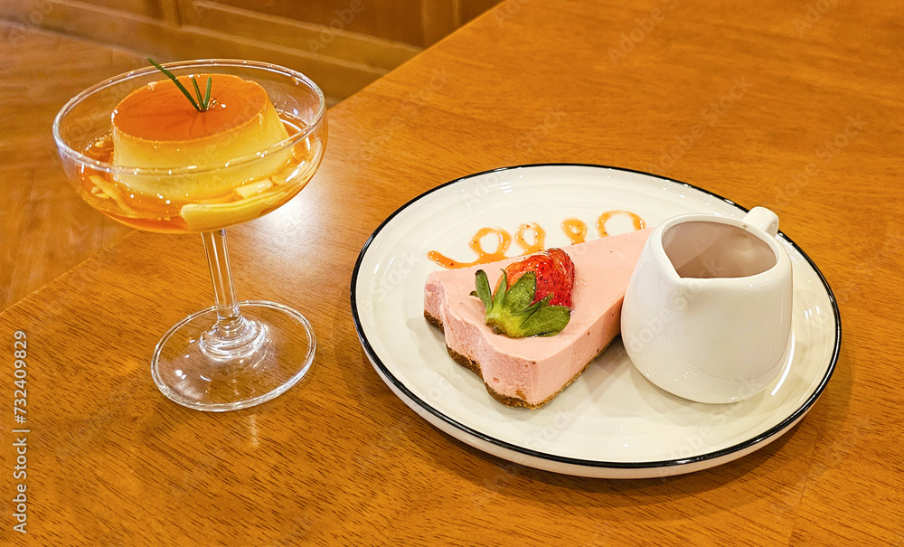 A beautifully plated strawberry cheesecake slice and caramel pudding served with sauce, showcasing culinary art on a wooden table A beautifully plated strawberry cheesecake slice and caramel pudding served with sauce, showcasing culinary art on a wooden table