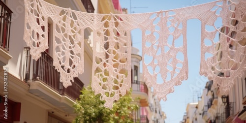 A street with a bunch of white crocheted laces hanging from a line. This image can be used to depict a creative and decorative street scene
