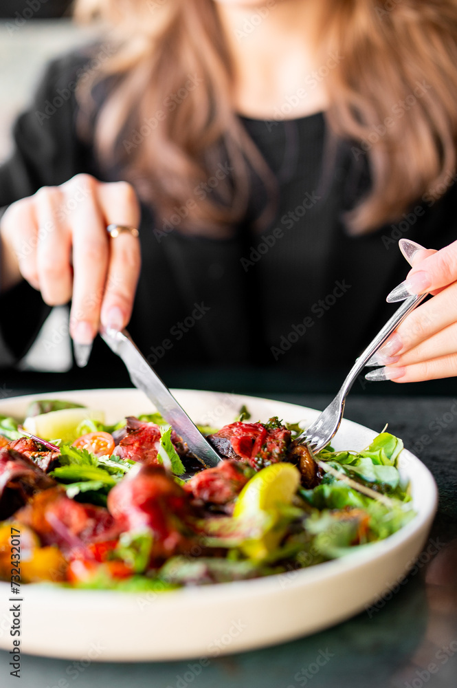 woman hands with knife and fork eat Fresh salad