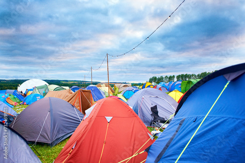 Camping, tents and outdoor music festival in park on holiday or vacation in summer. Camp, site and shelter setup at party, event or travel in countryside for concert, adventure and crowded carnival photo