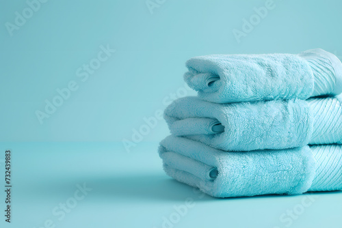 Light blue spa towels pile  bath towels lying in a stack on light blue peaceful background with copy space