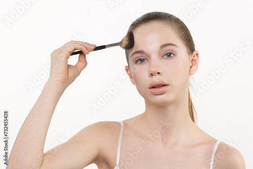Gentle Nude beauty portrait of a girl with a brush for a make-up isolated on white background