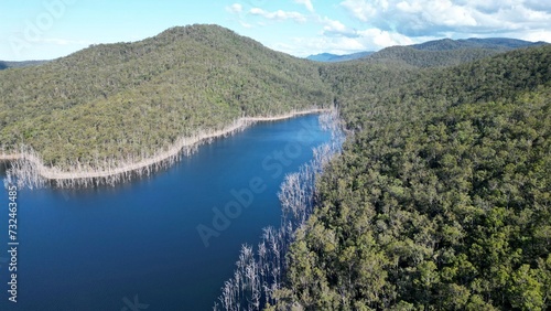 Εκτύπωση καμβά Scenic aerial view of a tranquil lake surrounded by lush green hills, creating a