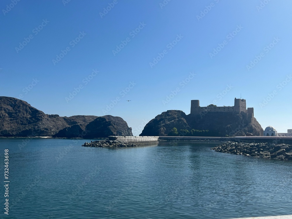 Of historic Castle on the rocky shoreline in Muscat,Mutrah against a blue sky