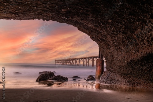 Idyllic beach with pristine golden sand and a bridge over ocean at sunset in Catherine Hill Bay photo