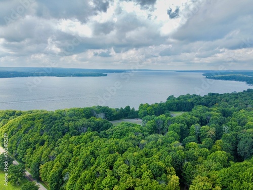Aerial view of a pristine lake surrounded by a lush green forest.
