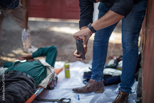 Man taking picture of person on stretcher in an emergency situation