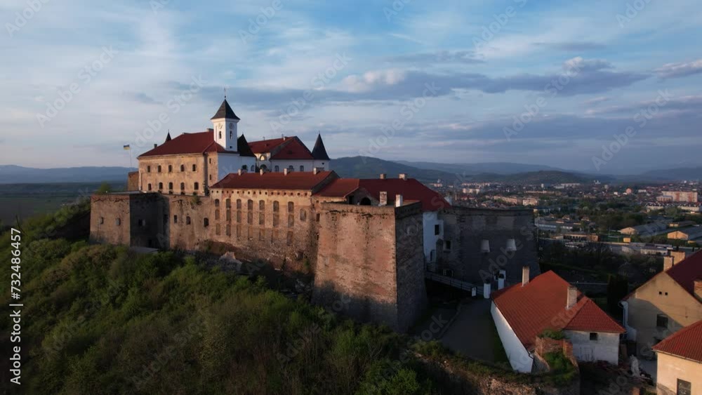 Old medieval Mukachevo Castle on a sunset aerial footage with beautiful blue sky Old medieval Mukachevo Castle on a sunset aerial footage with beautiful blue sky