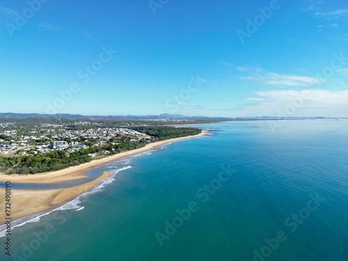 the beach and ocean in a clear blue sky above sand dunes