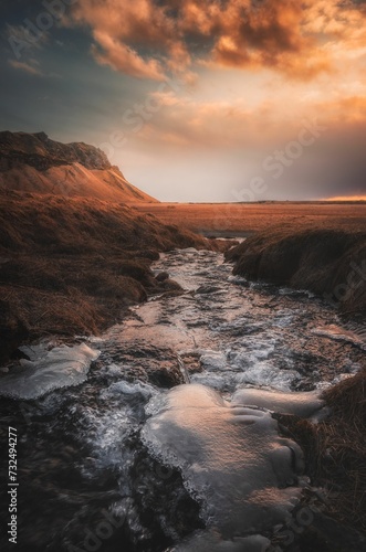 Amazing sunset view behind the stream flow in the area of Seljalandsfoss waterfall.