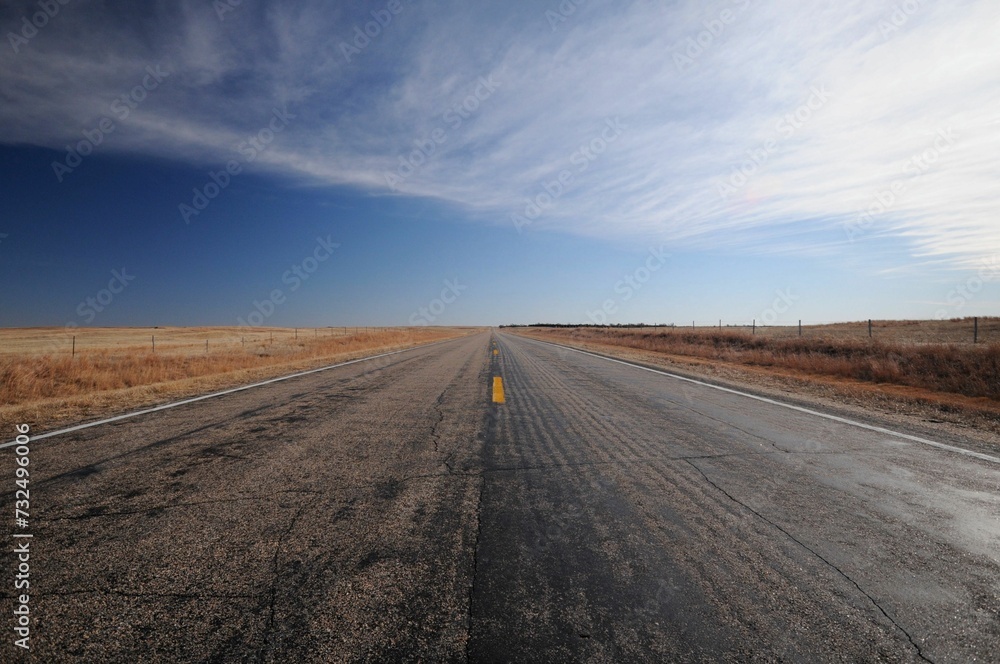 Scenic view of an abandoned road with a blue sky in the background