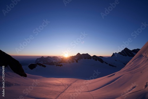 Scenic view of a mountain range covered with snow at sunset