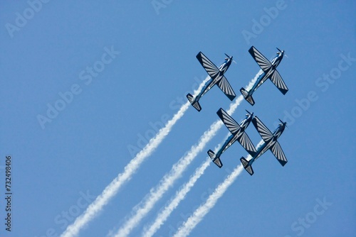 Canvas Print a formation of four airplanes flying through the sky at a military ceremony