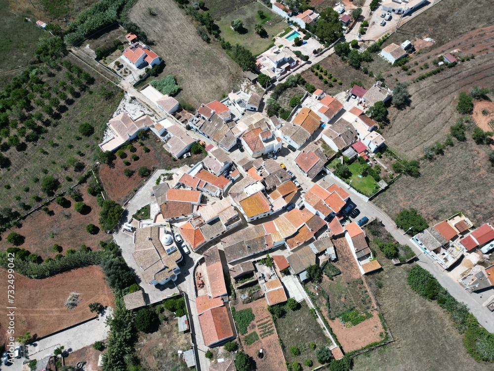 Aerial view of a rural town situated among lush, rolling hills