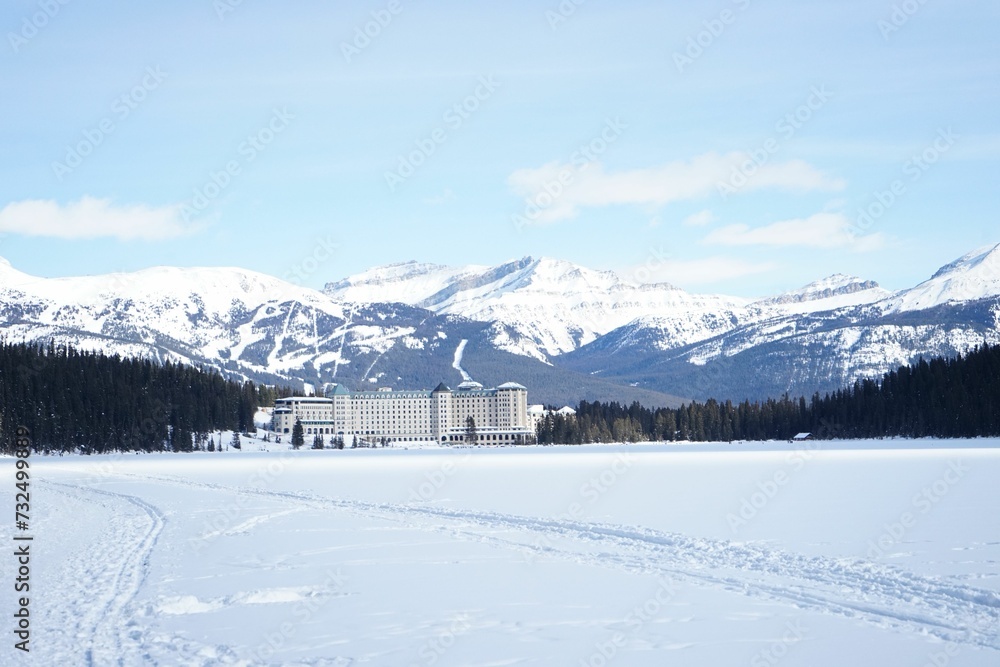 Large resort in a winter landscape covered in white snow and majestic mountains peaks in backdrop