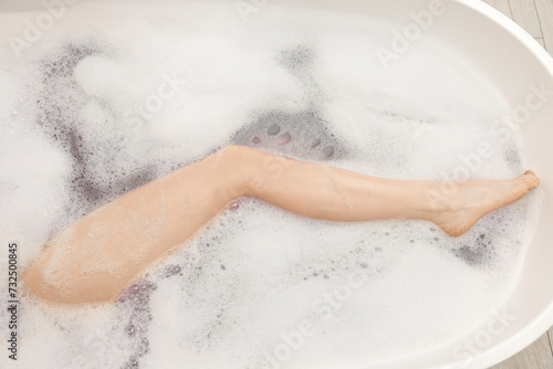 Woman taking bath with foam in tub  top view