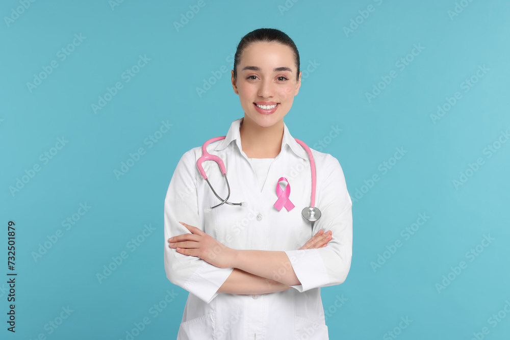 Mammologist with pink ribbon on light blue background. Breast cancer awareness Mammologist with pink ribbon on light blue background. Breast cancer awareness