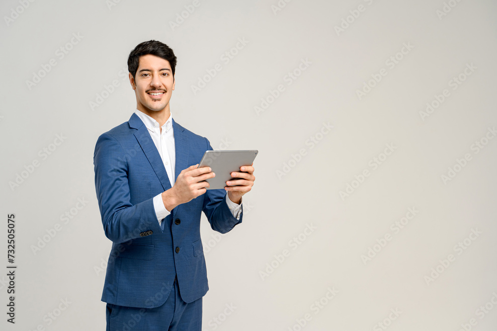 A man in a blue suit confidently uses a tablet, his smile conveying ease and expertise with technology, concept of business communications, digital solutions, and tech-facilitated business management A man in a blue suit confidently uses a tablet, his smile conveying ease and expertise with technology, concept of business communications, digital solutions, and tech-facilitated business management
