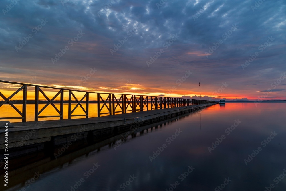 Scenic view of a bridge arched over a body of water at sunset.