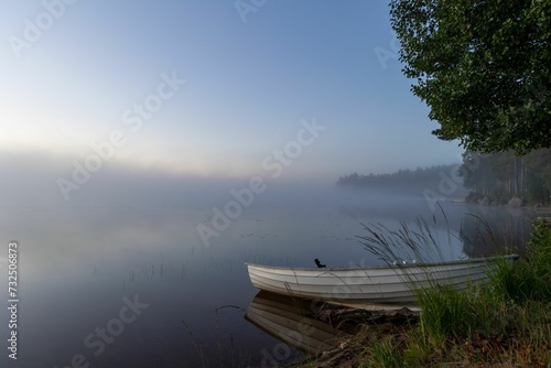 Boat docked at the lake shore during the evening.