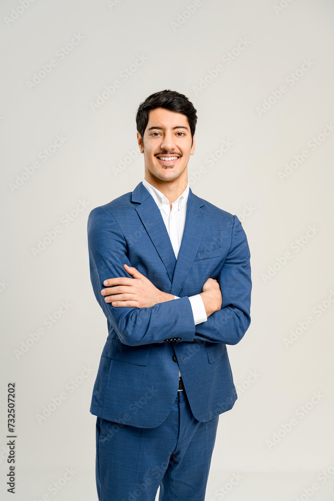 With a confident stance and a friendly smile, this young man in a tailored blue suit personifies the energetic and optimistic spirit of a rising star in the business world, isolated on white With a confident stance and a friendly smile, this young man in a tailored blue suit personifies the energetic and optimistic spirit of a rising star in the business world, isolated on white