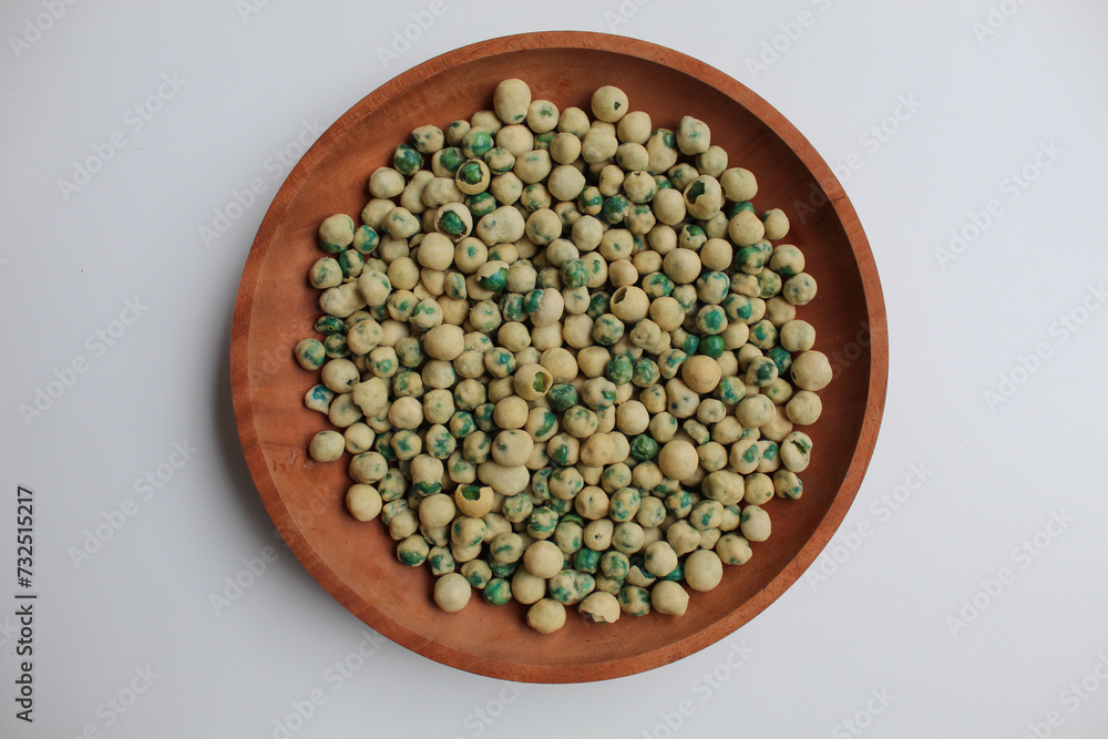 Fried green peas with dough flour, flat lay or top view, on w wooden plate, isolated on white background Fried green peas with dough flour, flat lay or top view, on w wooden plate, isolated on white background