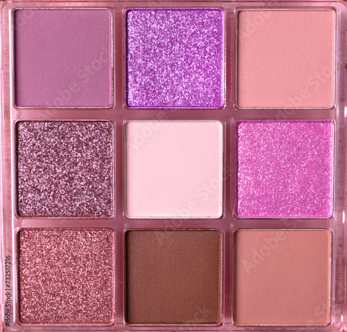 Eyeshadow palette with shimmer and matte warm colors. Nine bright and neutral colors in squares. Full frame. Make-up background