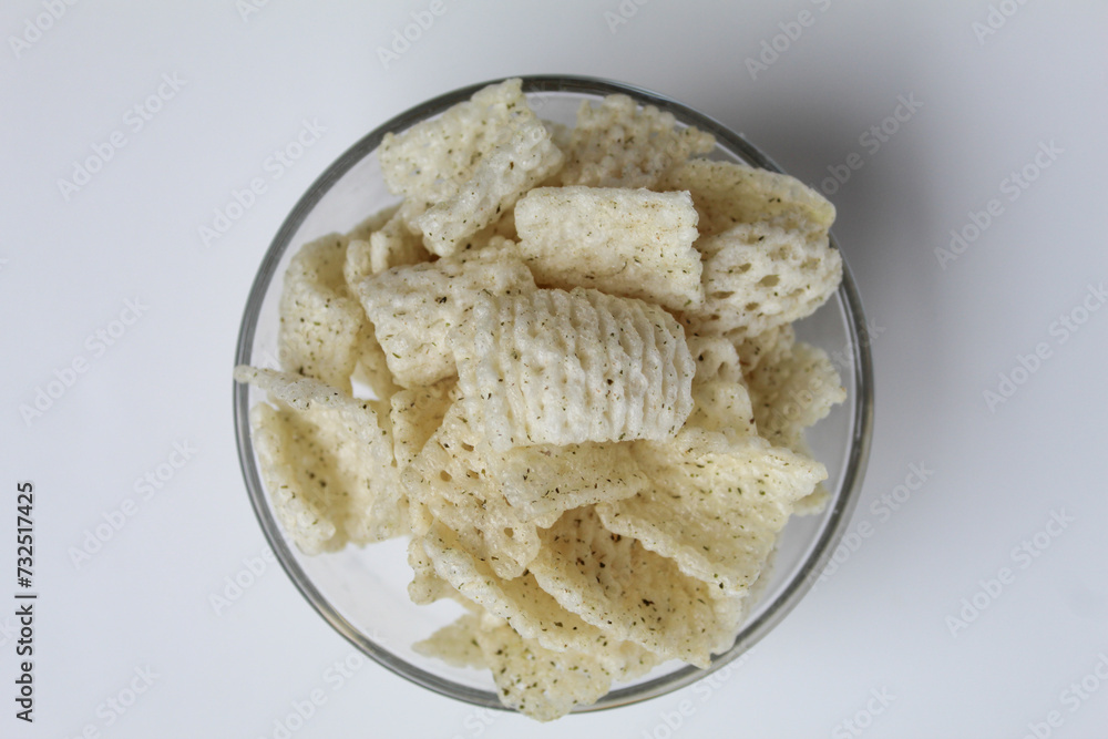 Crackers in net shape, in transparent glass bowl. isolated on white background, flat lay or top view Crackers in net shape, in transparent glass bowl. isolated on white background, flat lay or top view